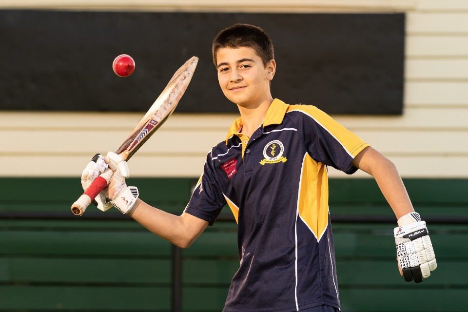 Young cricket player using one hand to bat